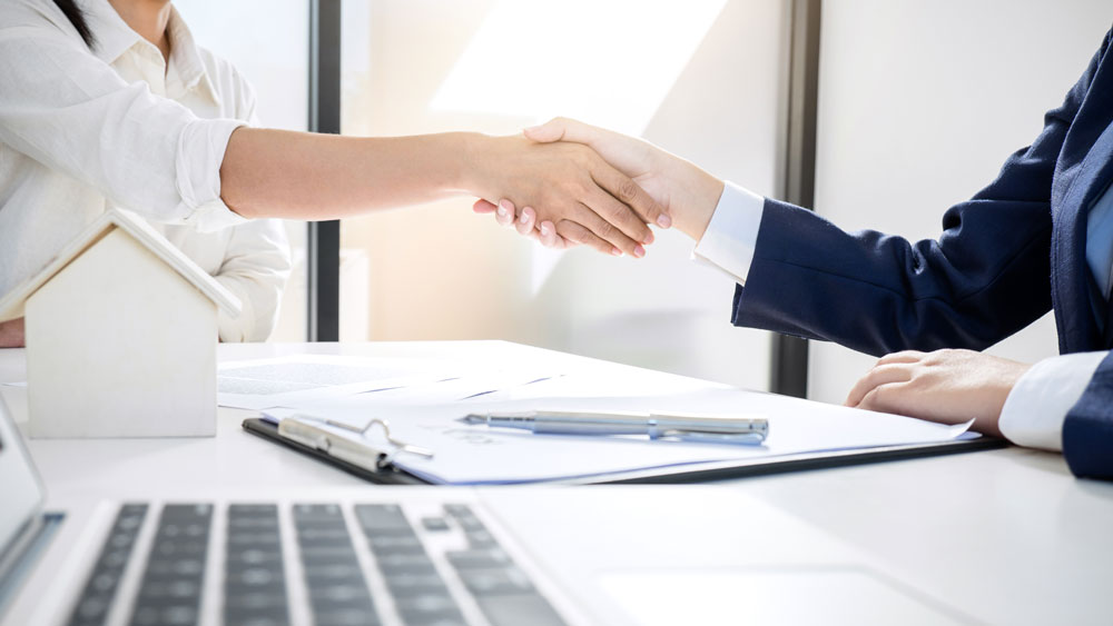 Two People in an Office Making a Deal on Selling a House | CRM Properties